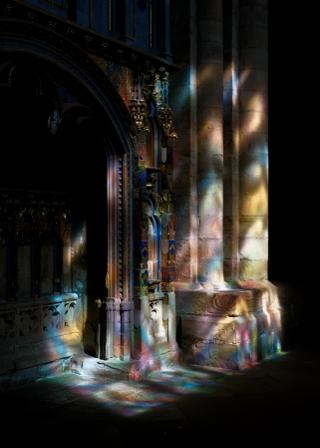 Light and shadows creating colourful visual effects over part of a tomb.