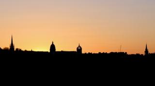 Silhouette of buildings against a sunset sky.